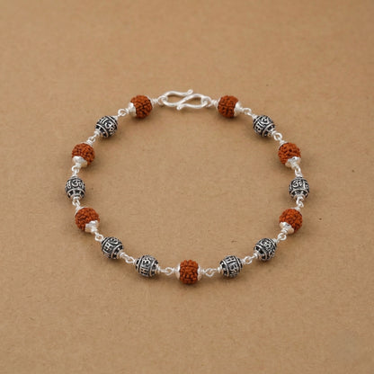 Rudraksha and silver bead bracelet placed on a beige background