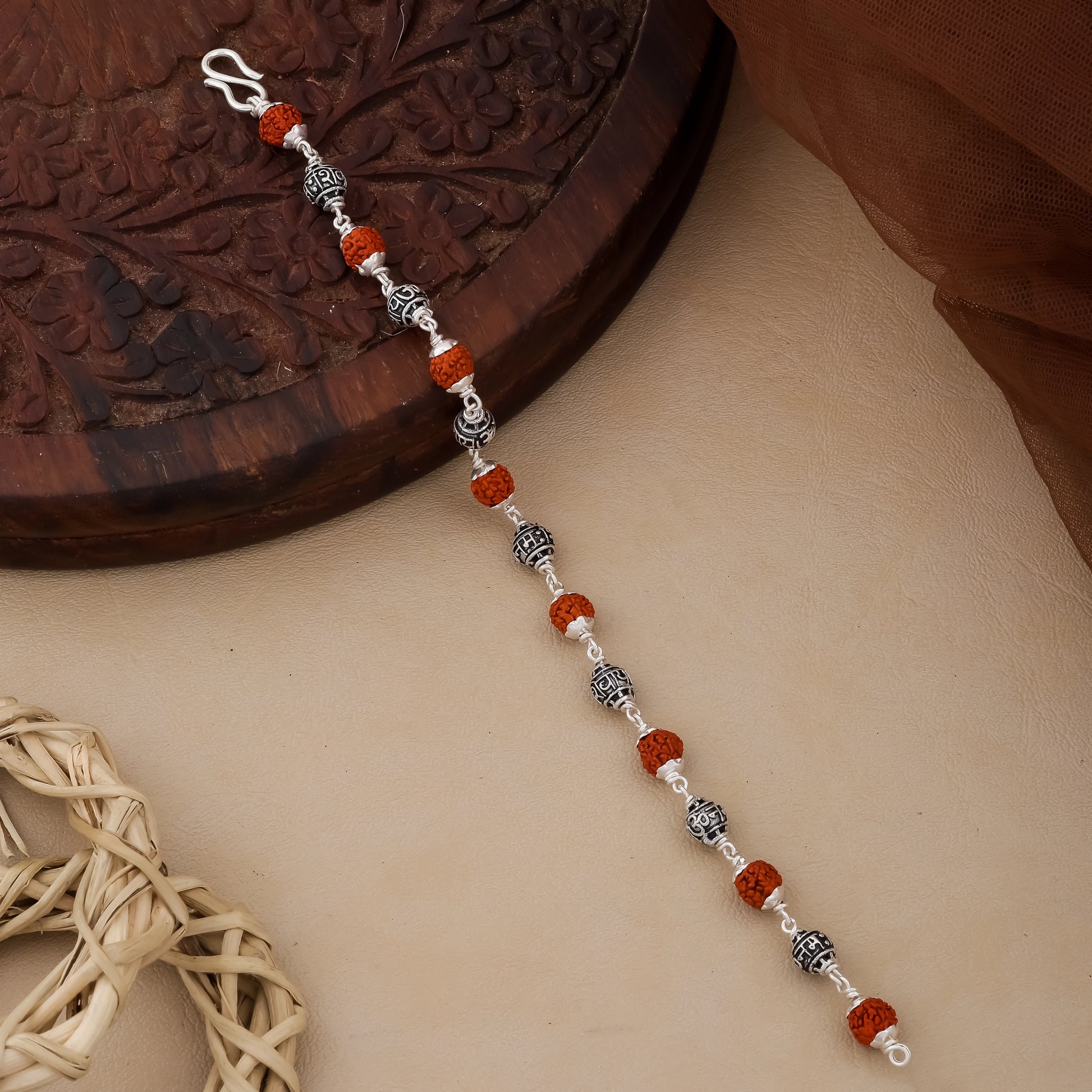 Beaded keychain with red and silver beads on a textured surface