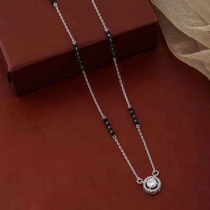 Silver necklace with a pendant on a red surface