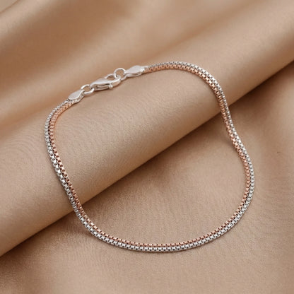 Silver bracelet on a person's wrist against a beige background