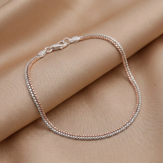 Silver bracelet on a person's wrist against a beige background