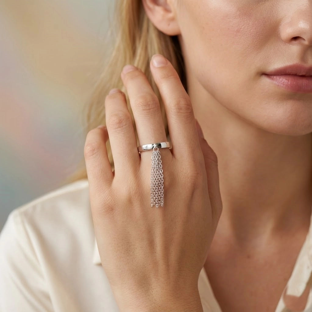 Close-up of a woman's hand wearing a silver ring with a chain design.