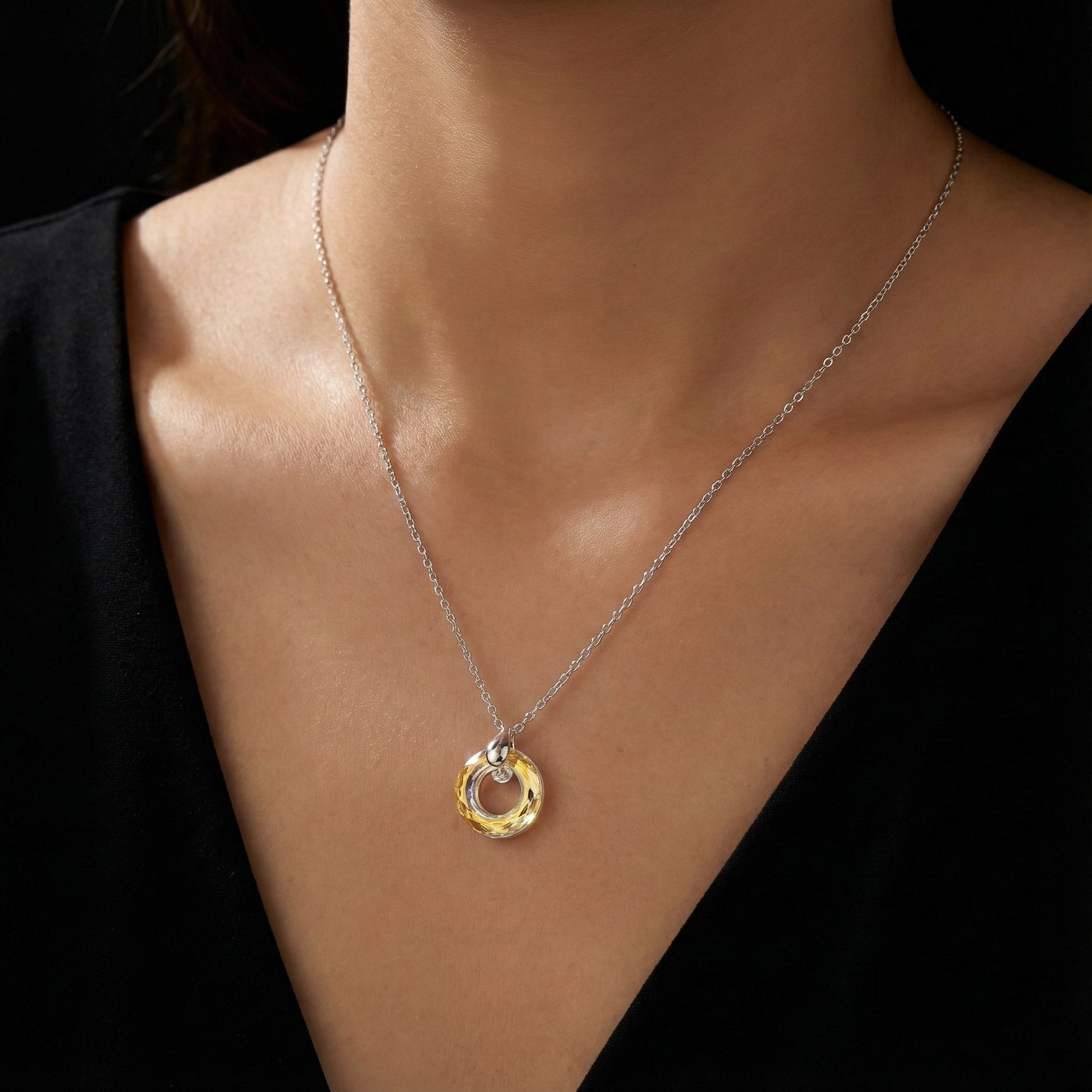 Necklace with a pendant on a model against a black background