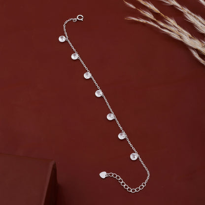 Silver bracelet with small beads on a dark red background