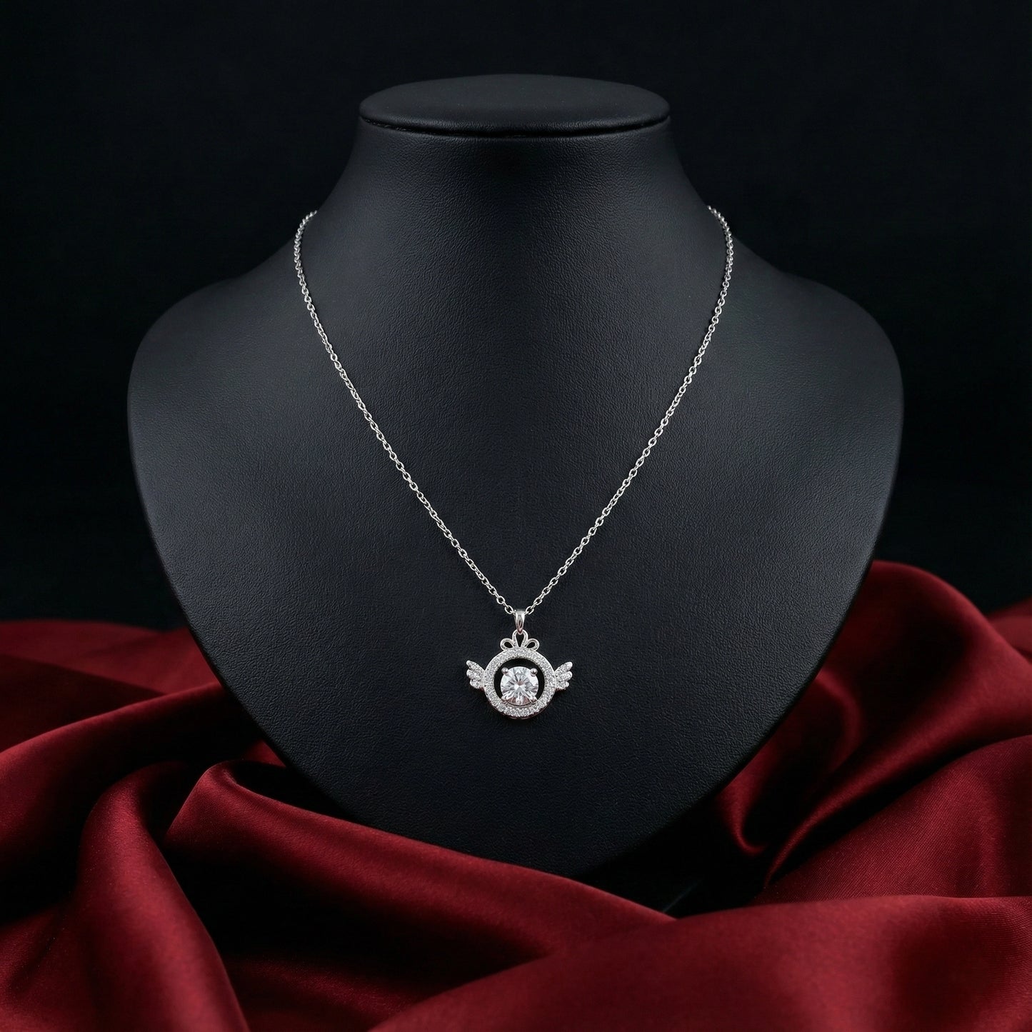 Silver necklace with a pendant on a black mannequin bust against a dark background