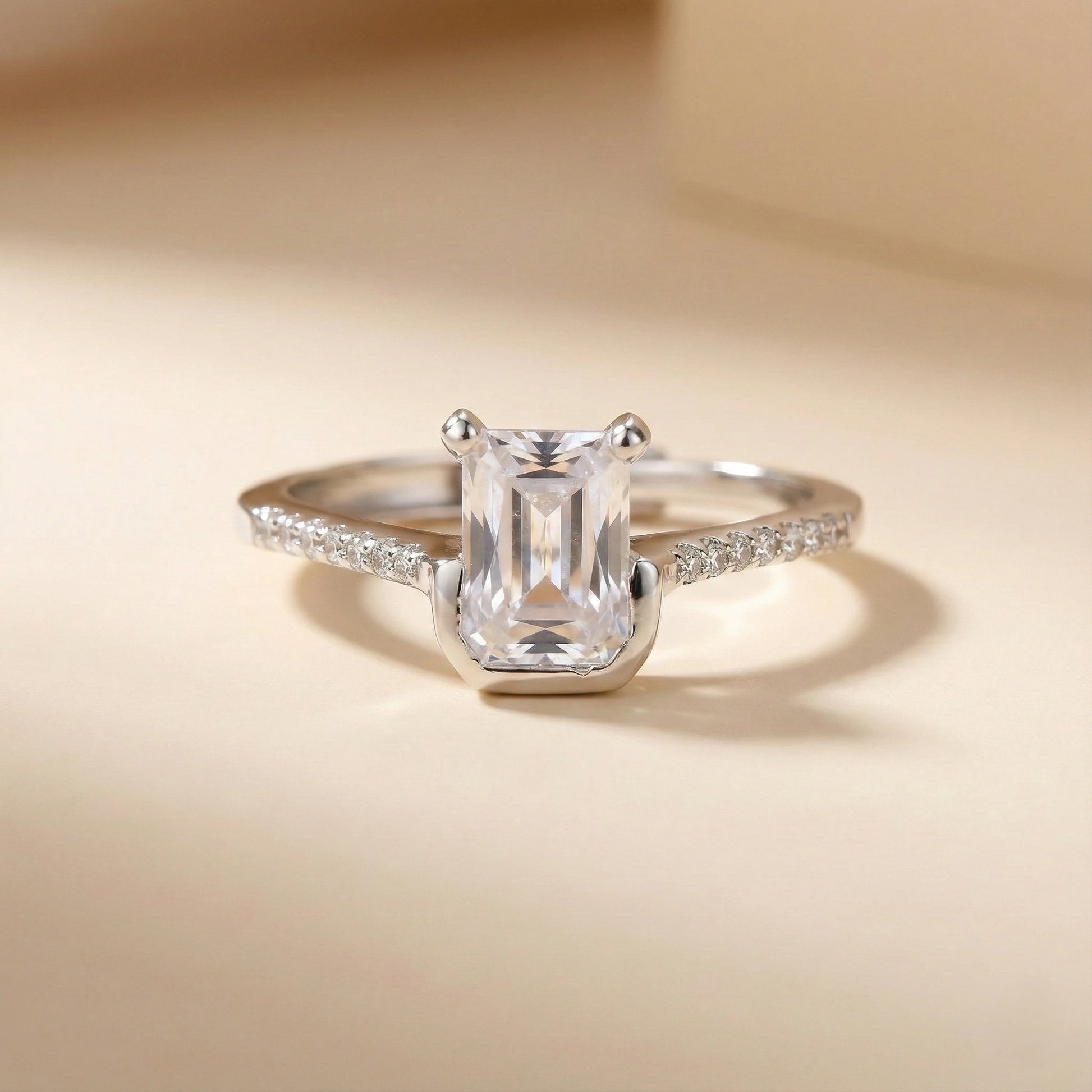 Silver ring with a large diamond on a beige background