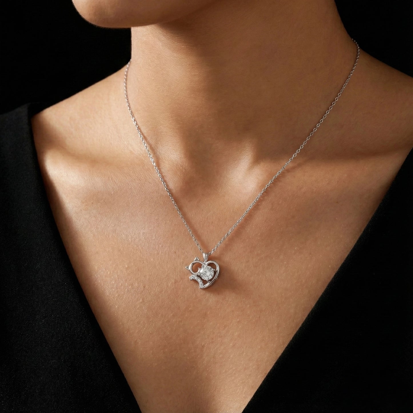 Necklace with a heart-shaped pendant worn by a person against a black background