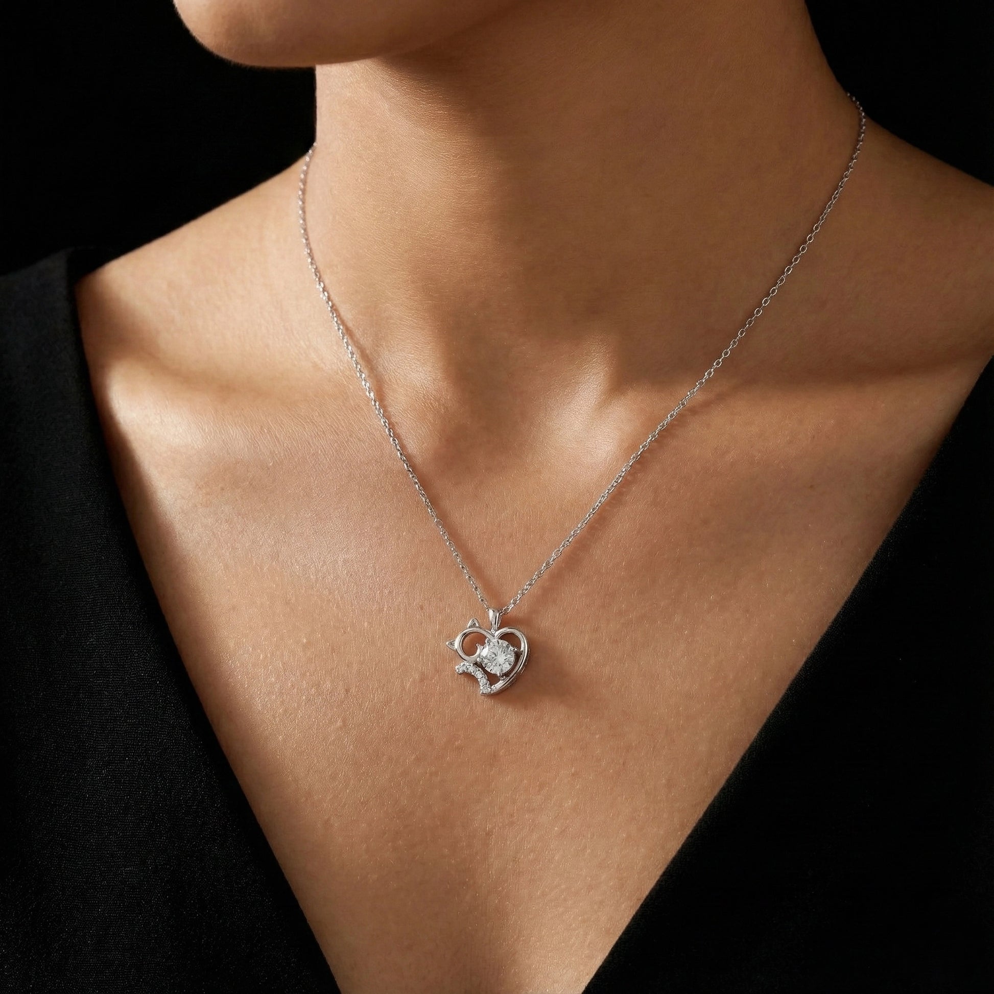 Necklace with a heart-shaped pendant worn by a person against a black background