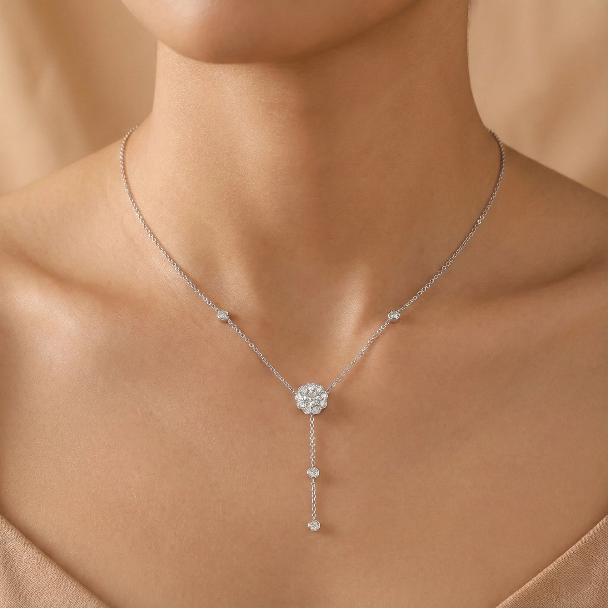 Silver necklace with a pendant on a model against a beige background