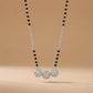 Necklace with black and silver beads on a beige background