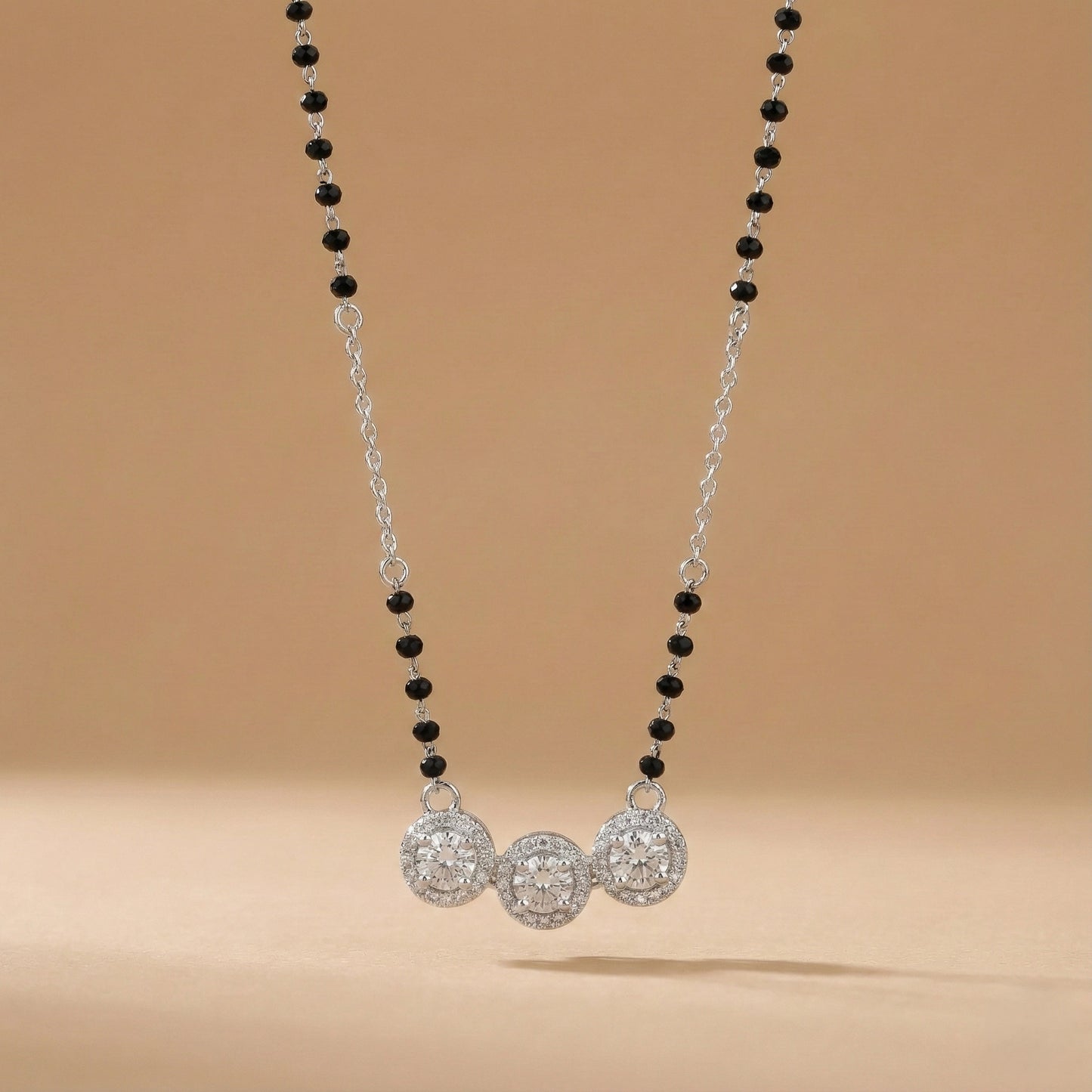 Necklace with black and silver beads on a beige background