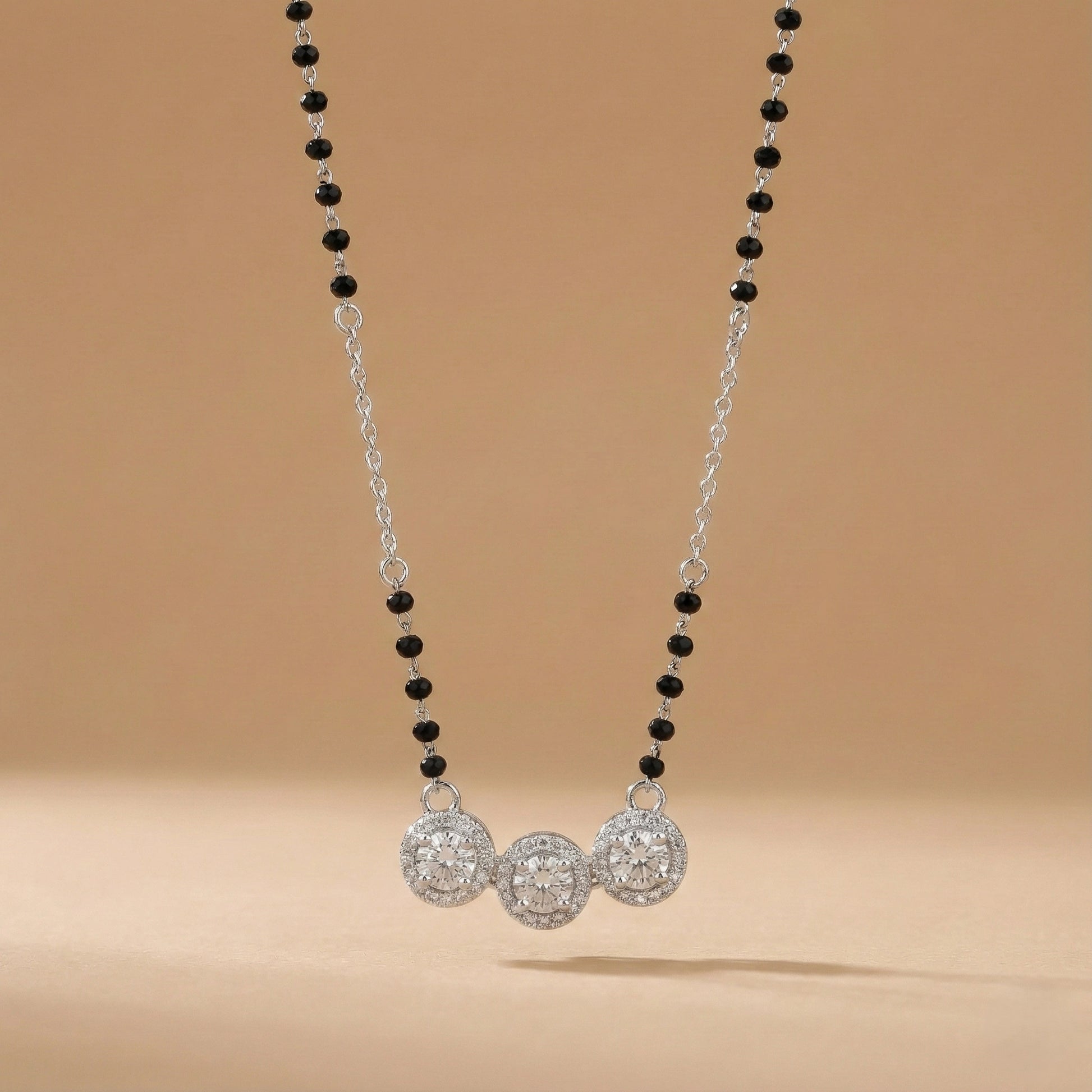 Necklace with black and silver beads on a beige background