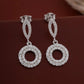 Silver earrings with circular design on a brown background