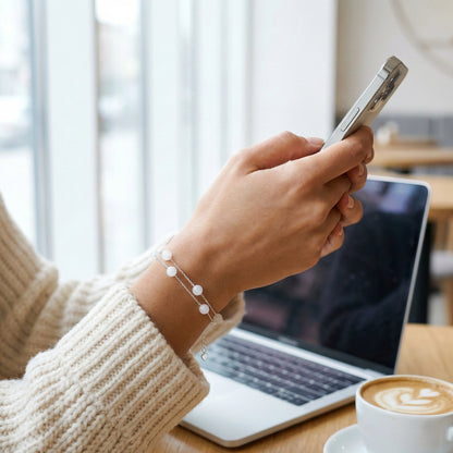 Double chain pearl bracelet on wrist in natural indoor light