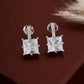 Pair of diamond earrings on a dark brown background