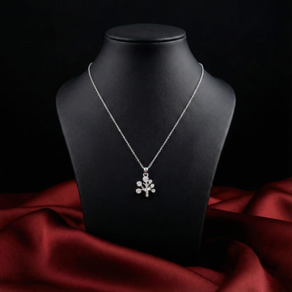 Silver necklace with a floral pendant on a black mannequin bust against a dark background