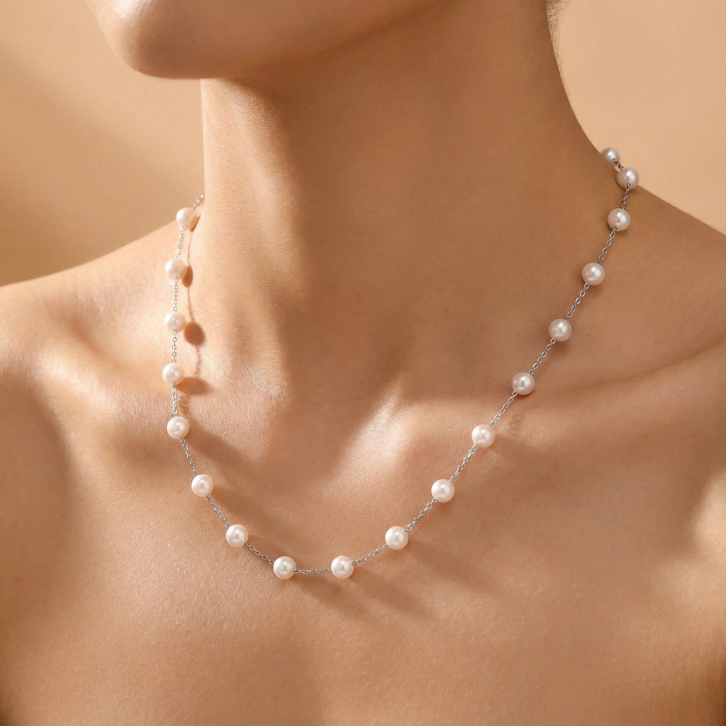 Pearl necklace on a person's neck against a neutral background