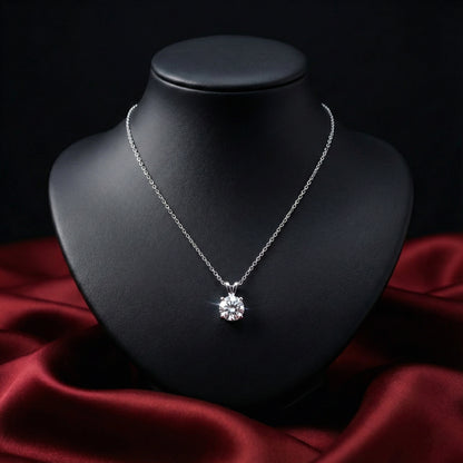 Silver necklace with a diamond pendant on a black mannequin bust against a red fabric background
