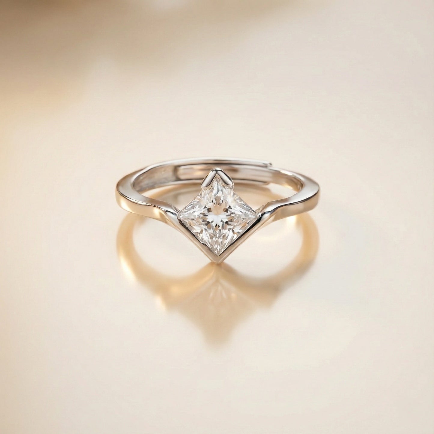 Silver ring with a diamond on a beige background