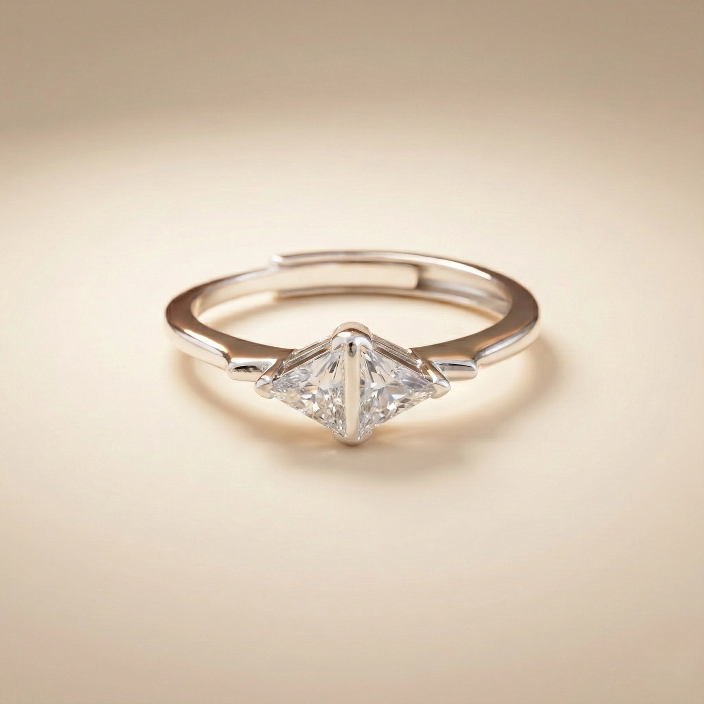 Diamond ring with a triangular cut gemstone on a beige background