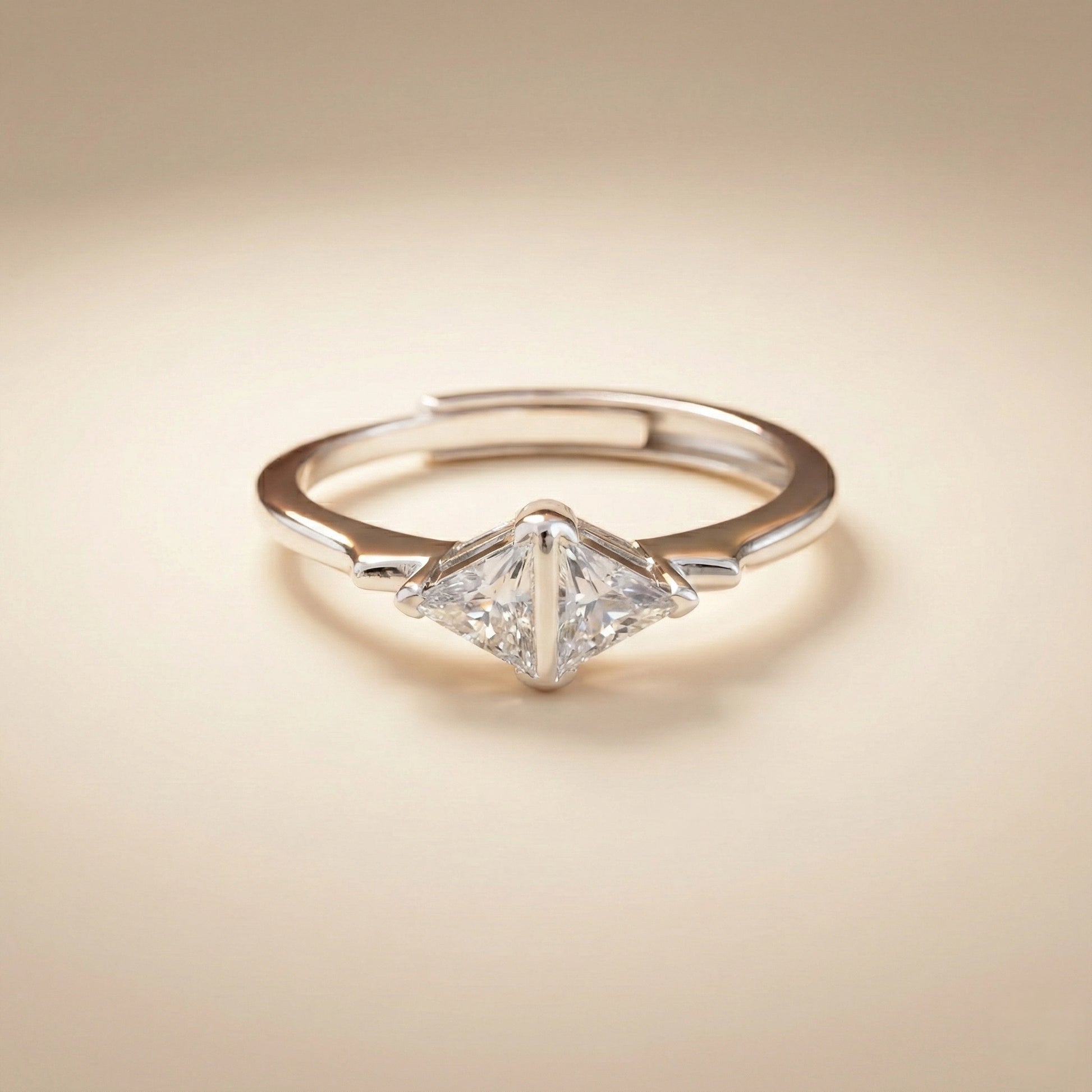 Diamond ring with a triangular cut gemstone on a beige background