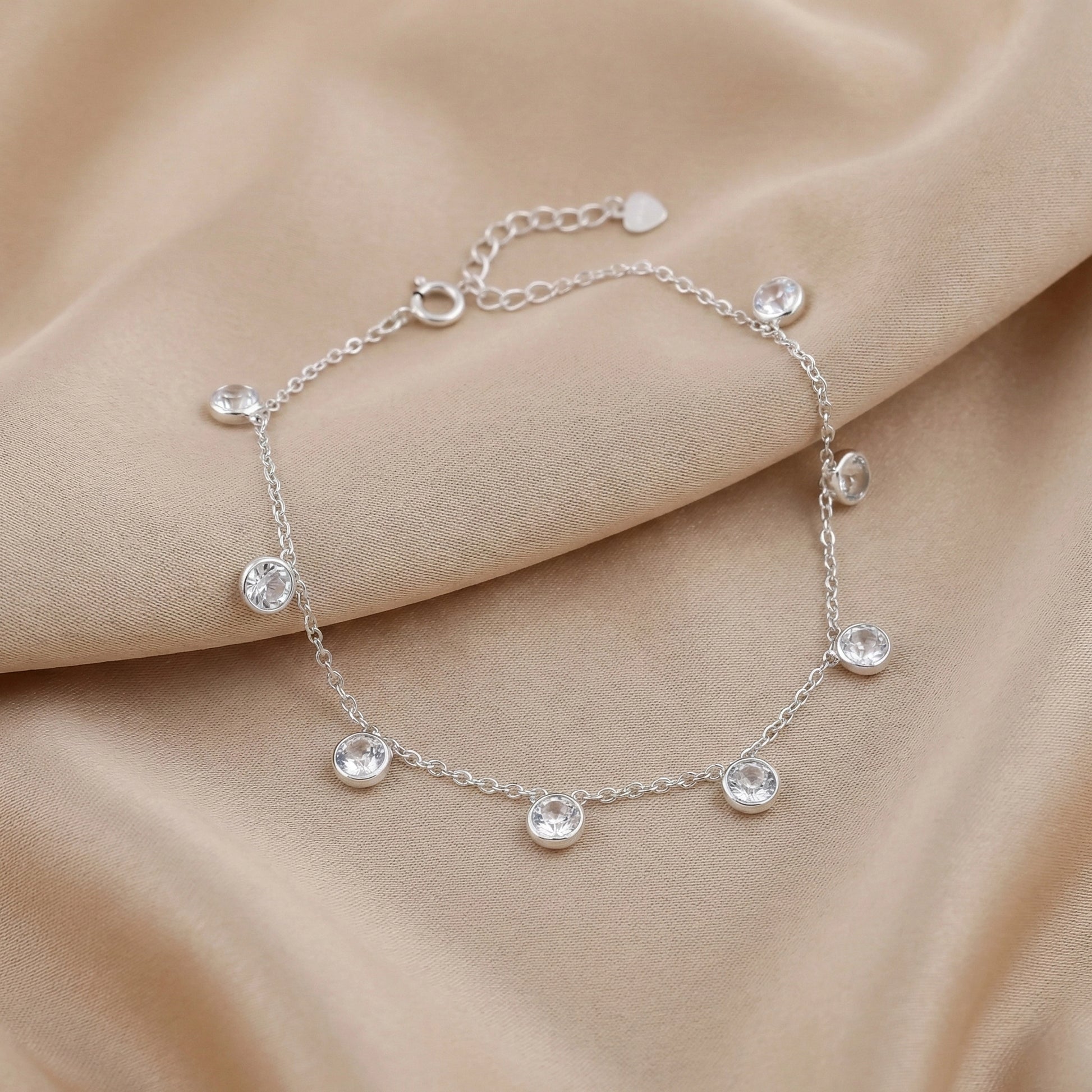 925 silver bracelet with clear crystal drop charms on maroon background