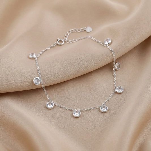 925 silver bracelet with clear crystal drop charms on maroon background