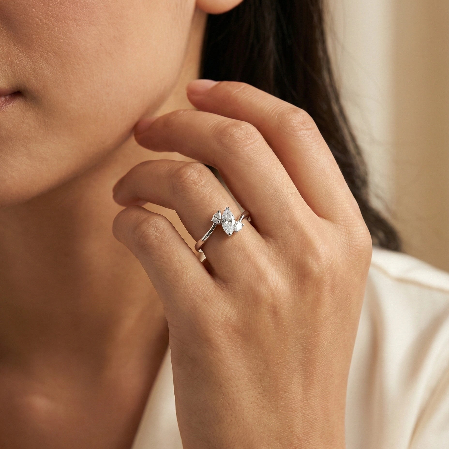 Close-up of a hand wearing a diamond ring with a blurred background