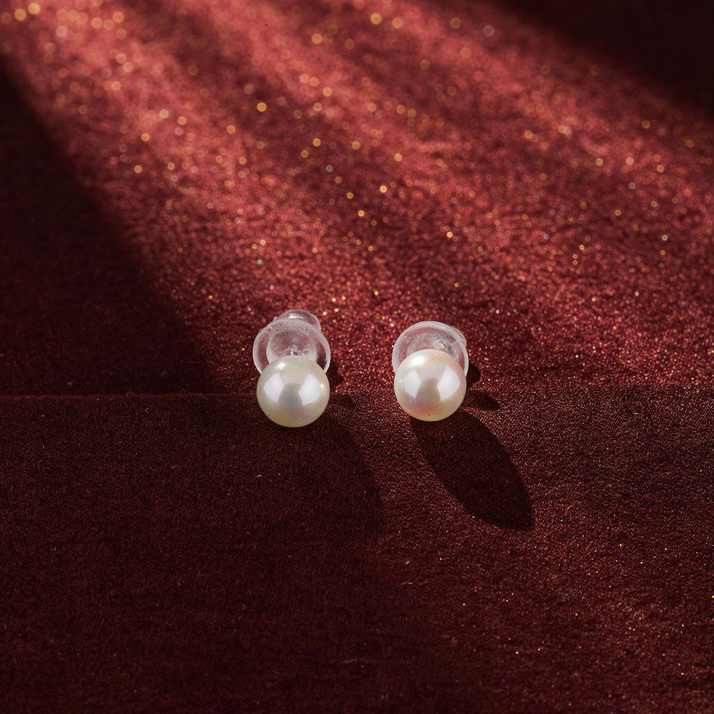 Pearl earrings on a red fabric background
