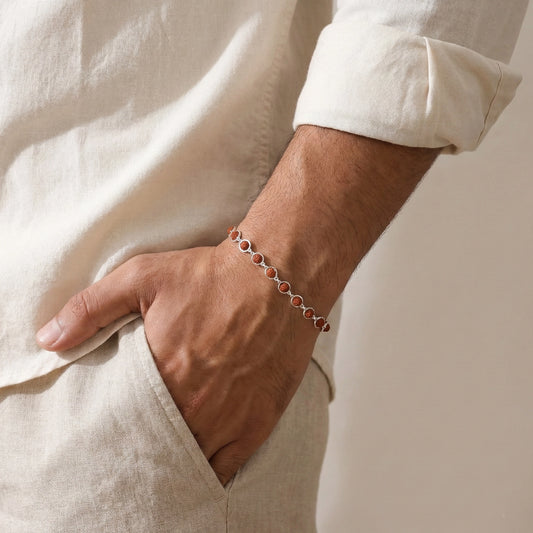 Close-up of a person wearing a bracelet on a plain background