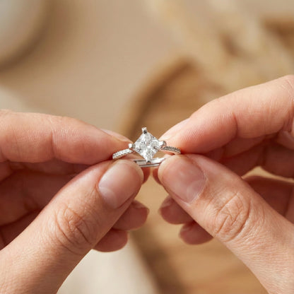 Close-up of hands holding a diamond ring against a blurred background