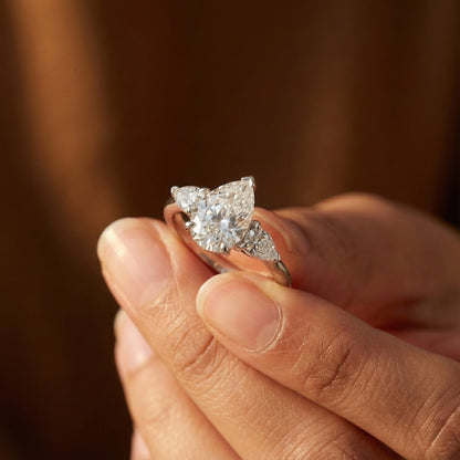 Diamond ring held in a hand with a blurred background