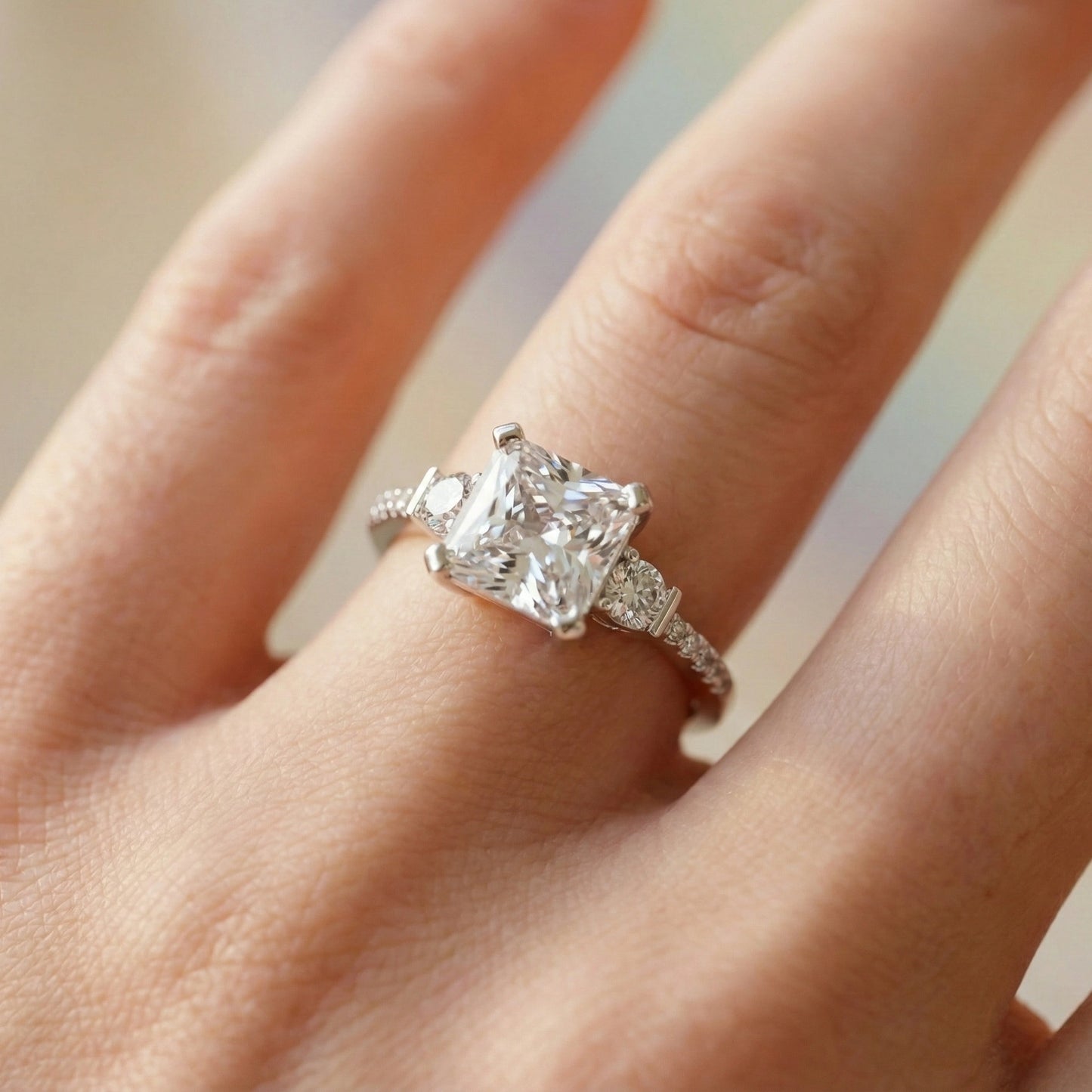 Diamond ring on a finger with a neutral background