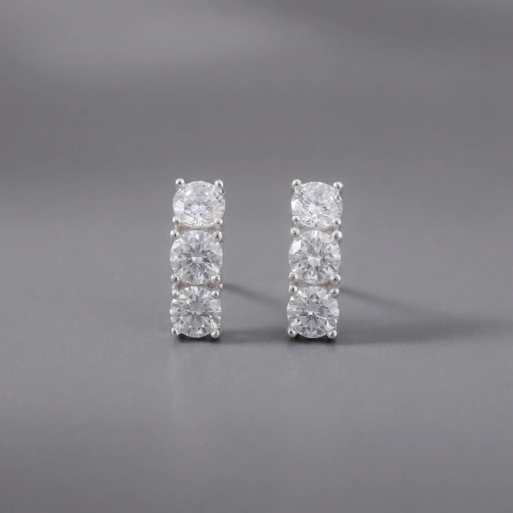 Pair of diamond stud earrings on a gray background