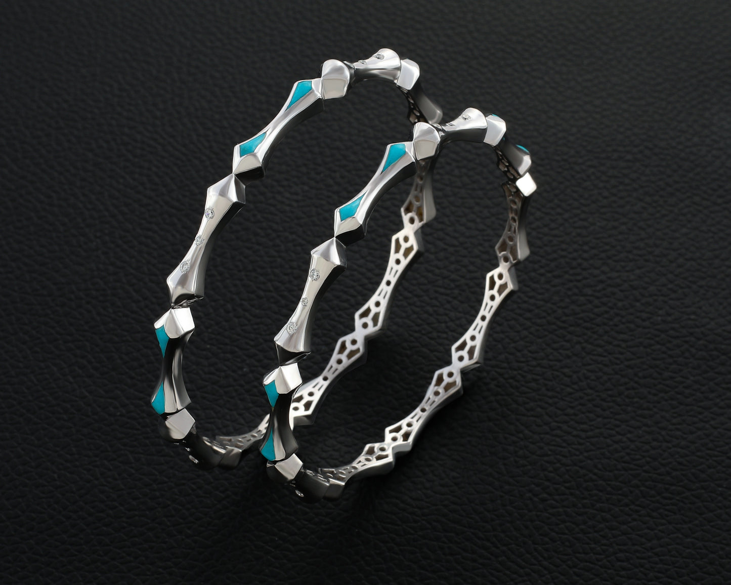 Silver hoop earrings with turquoise accents on a black textured background