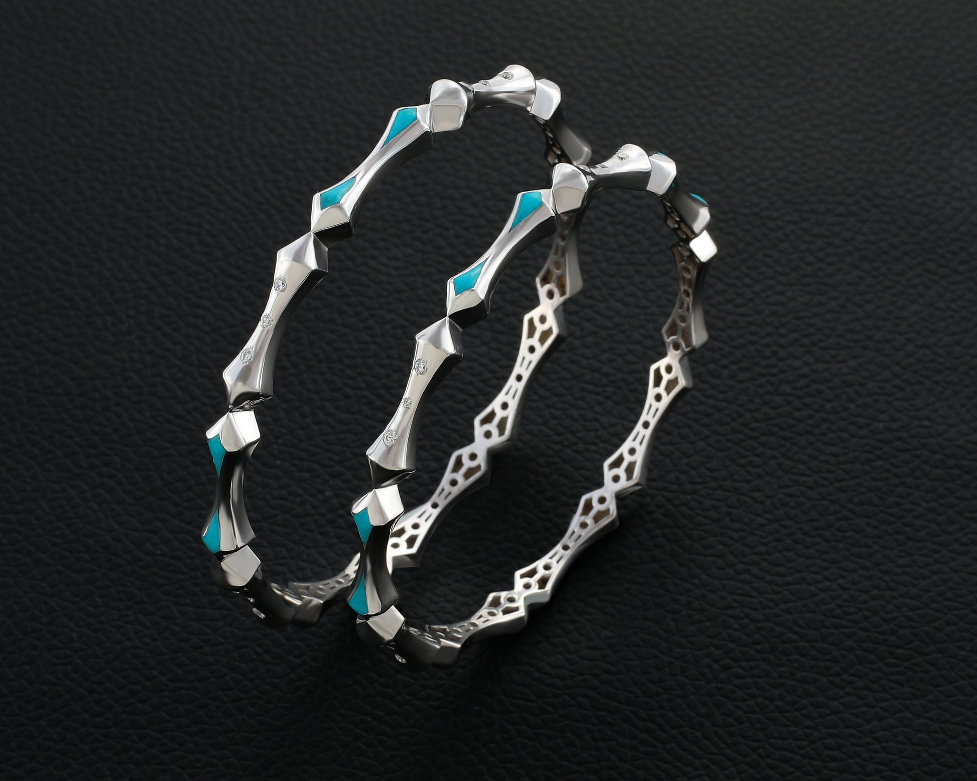 Silver hoop earrings with turquoise accents on a black textured background