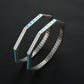 Silver hoop earrings with turquoise stones on a black textured background