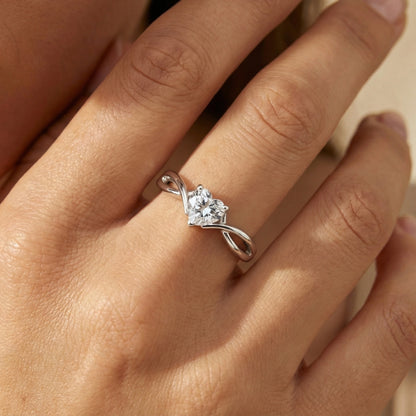 Silver heart-shaped diamond ring on a hand