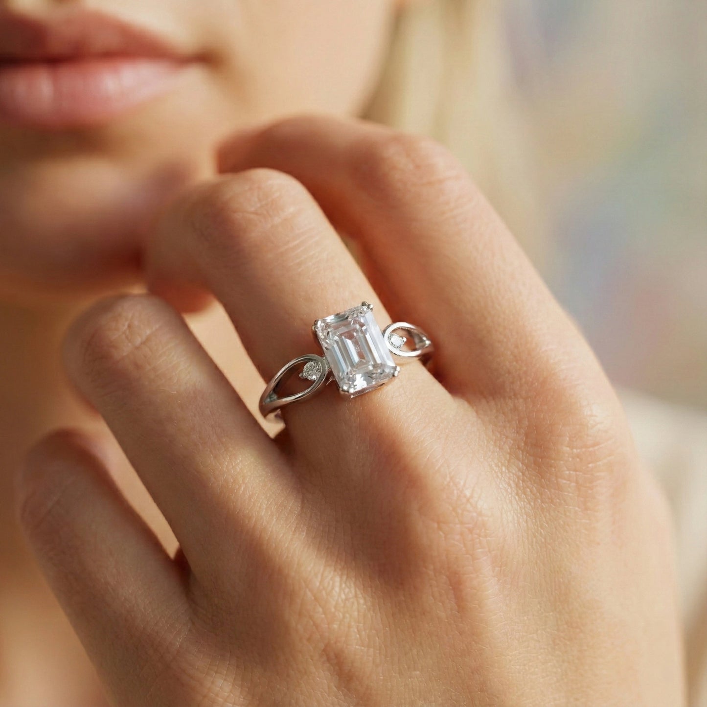 Close-up of a hand wearing a diamond ring with a blurred background