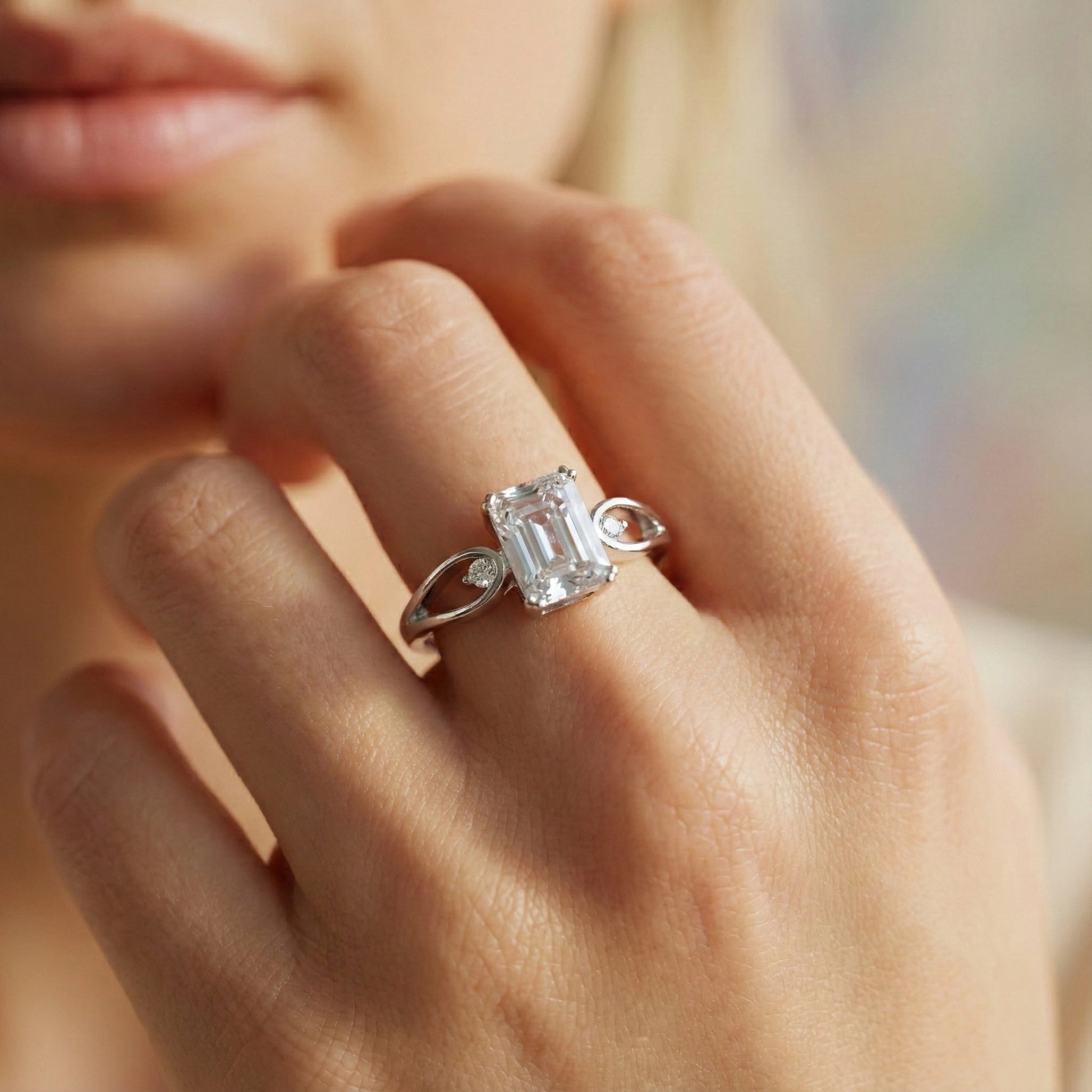 Close-up of a hand wearing a diamond ring with a blurred background