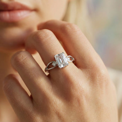 Close-up of a hand wearing a diamond ring with a blurred background
