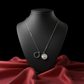 Necklace with a pendant on a black mannequin against a red fabric background