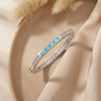 Two bracelets on a beige fabric background with dried grass accents