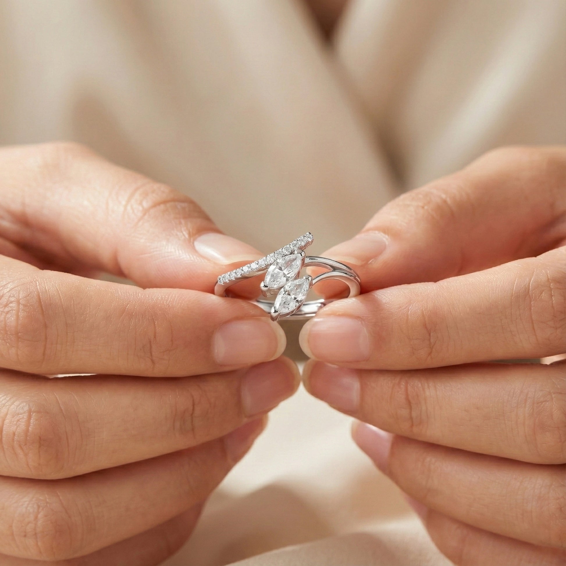 Close-up of hands holding a silver ring with a diamond