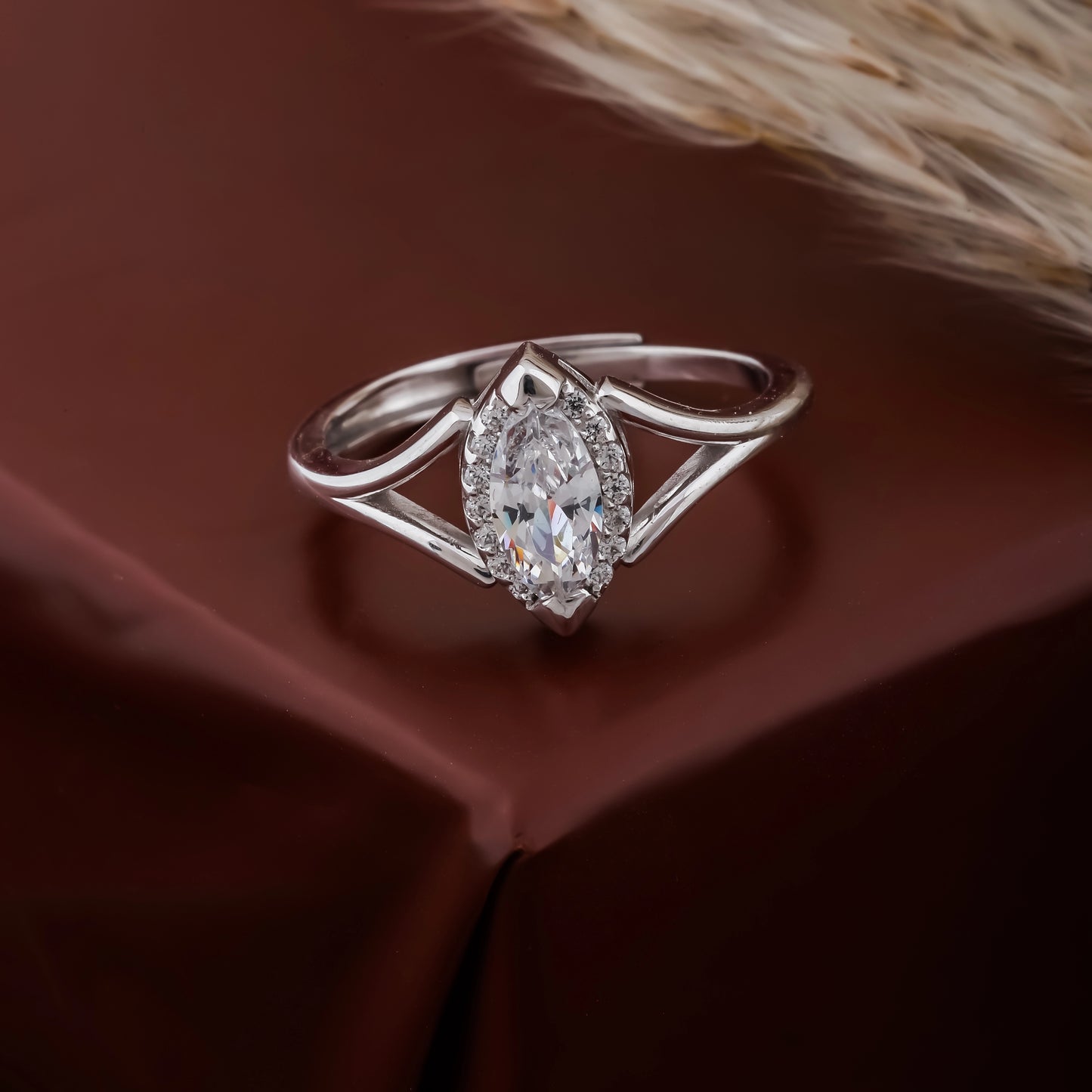 Silver ring with a diamond on a brown fabric background
