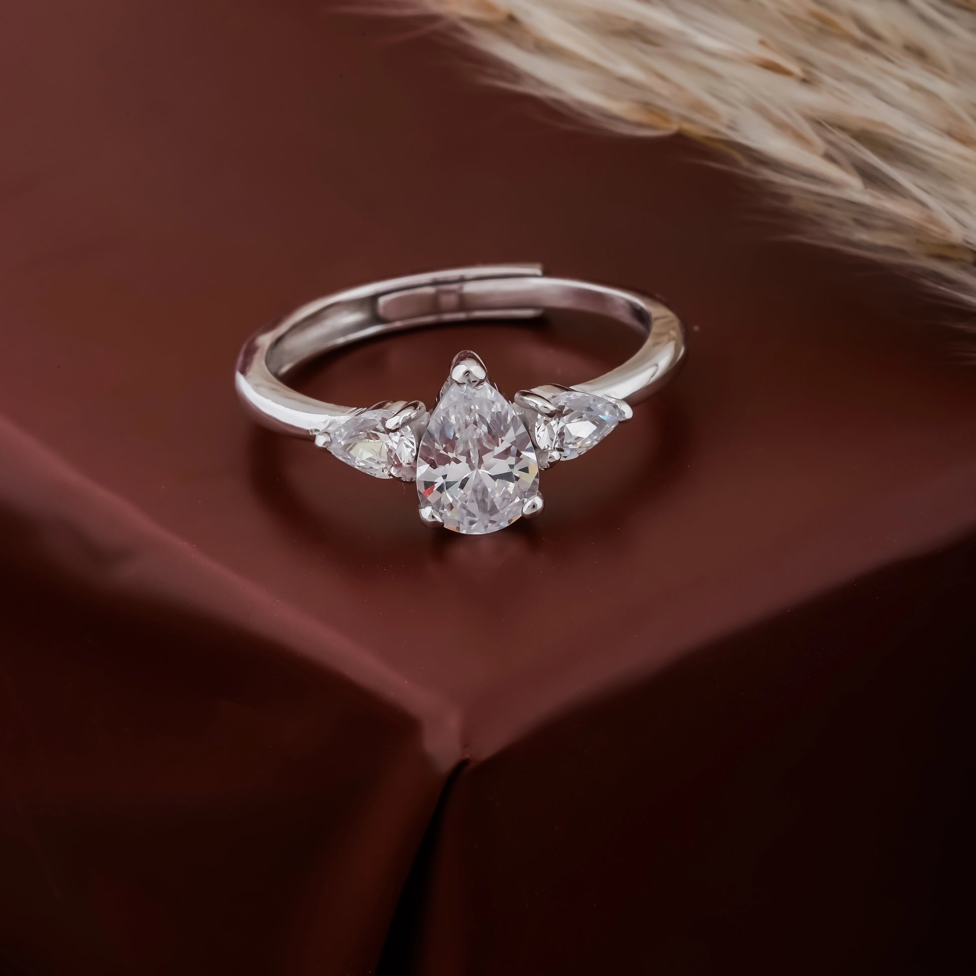 Silver ring with a diamond on a brown fabric background