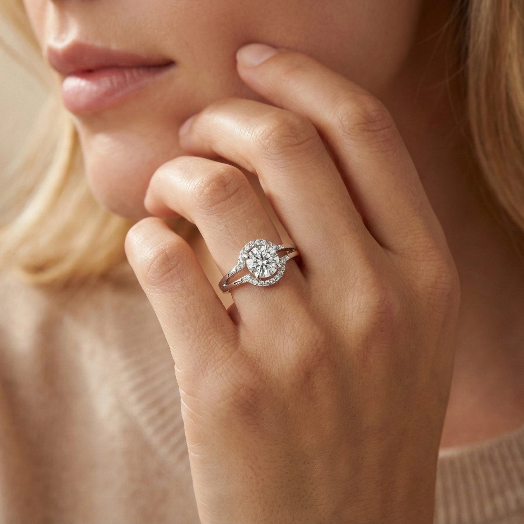 Close-up of a hand wearing a diamond ring with a blurred background
