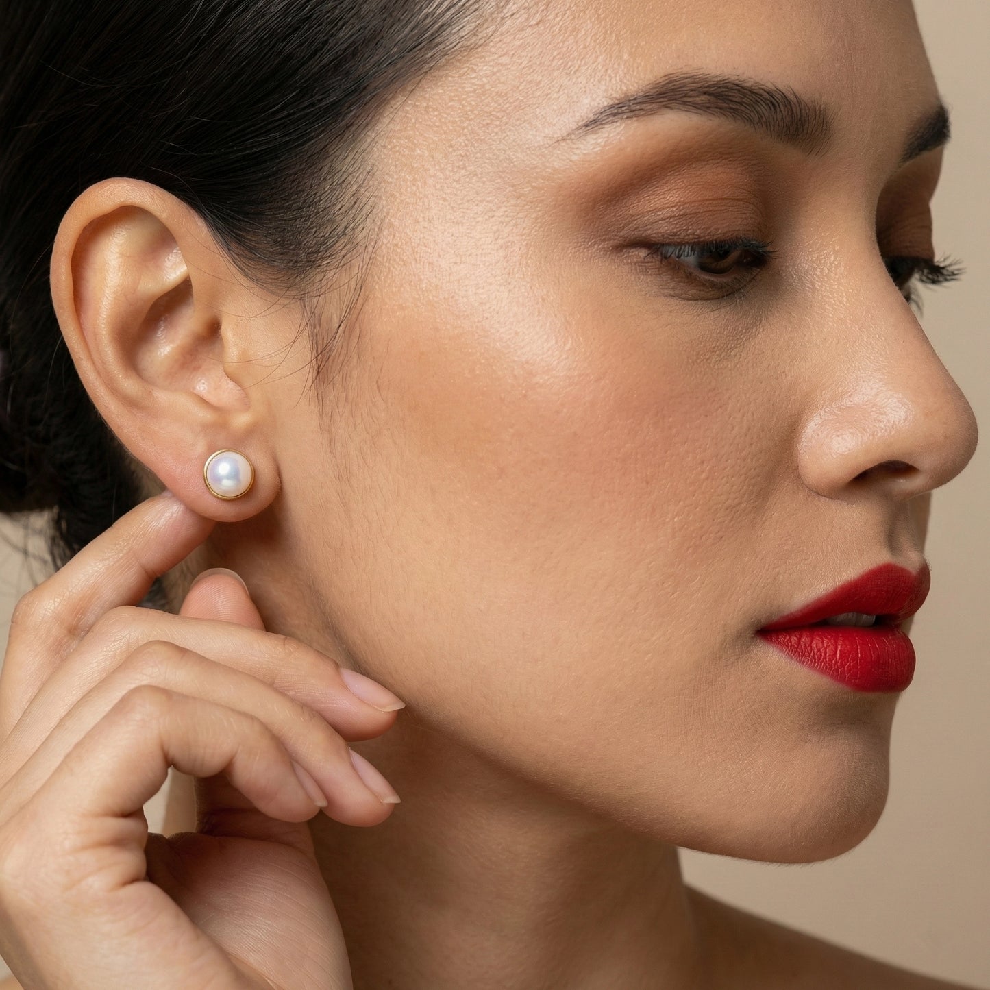 Classic white pearl studs arranged side by side on a dark backdrop