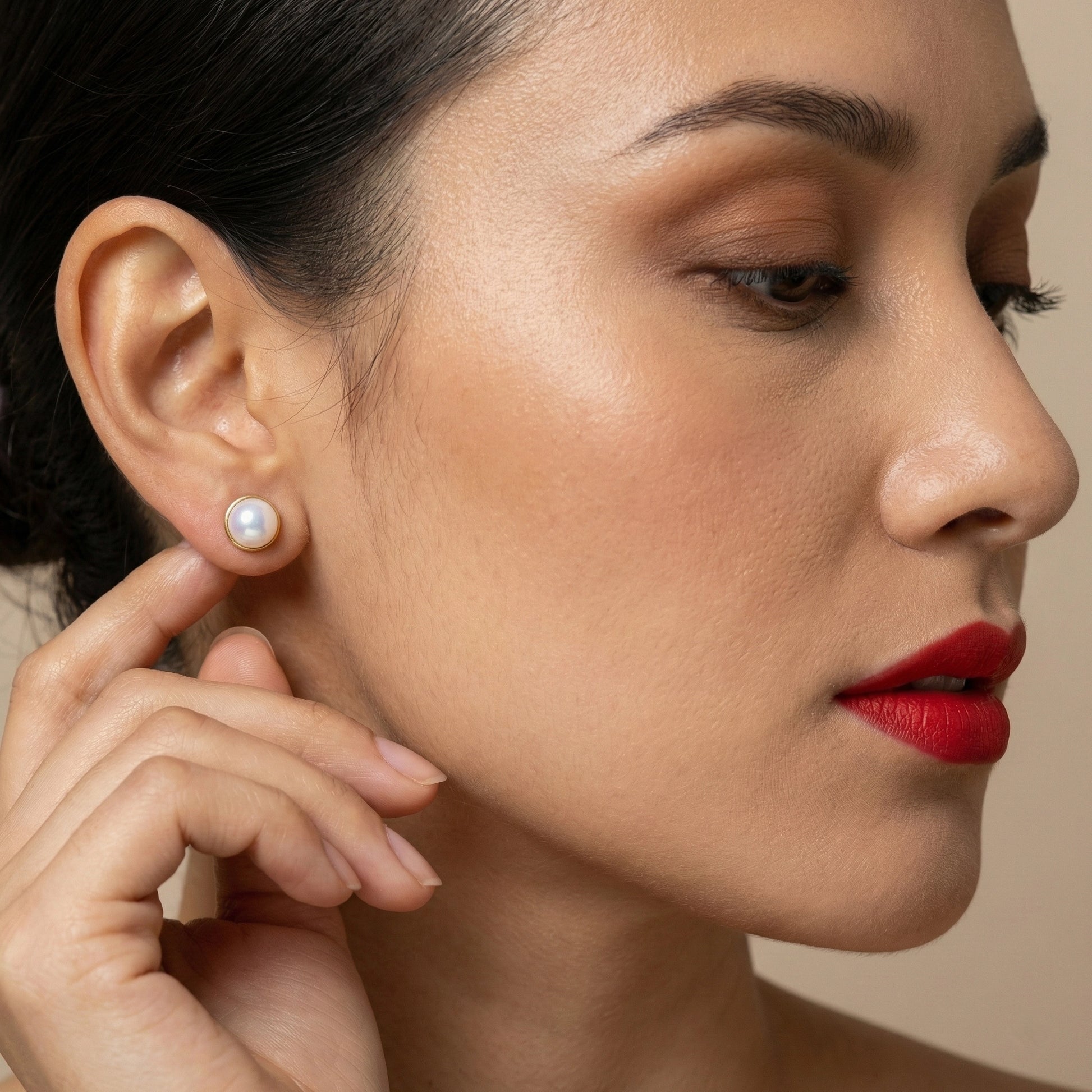 Classic white pearl studs arranged side by side on a dark backdrop