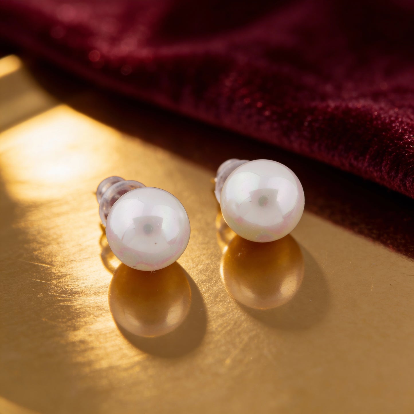 Close-up of a woman wearing a pearl earring with a neutral background